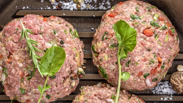 Seasoned burger patties topped with herbs