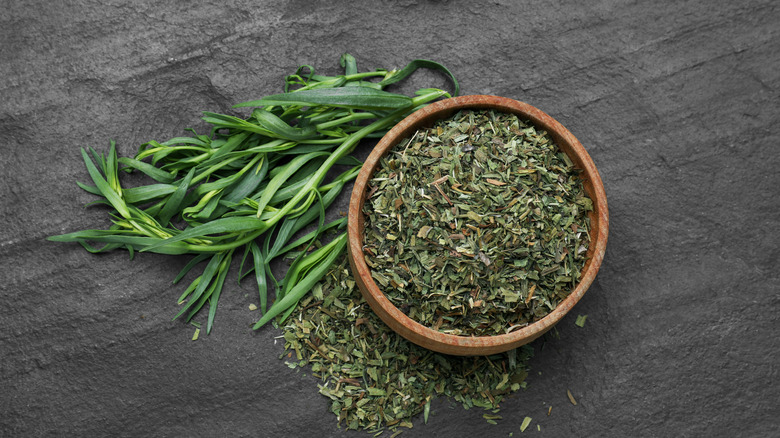 Fresh and dried tarragon on a slate surface