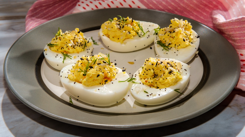 Plate of deviled eggs topped with everything bagel seasoning