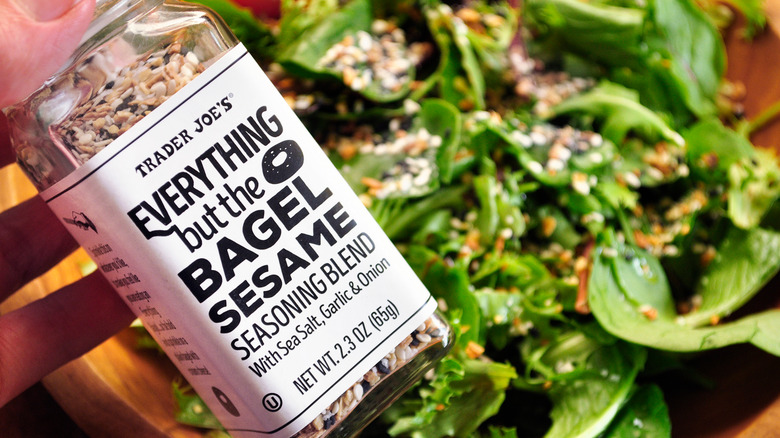 Jar of Everything But The Bagel Seasoning with bowl of leafy greens