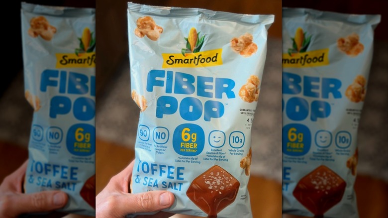 Person holding bag of Fiber Pop popcorn