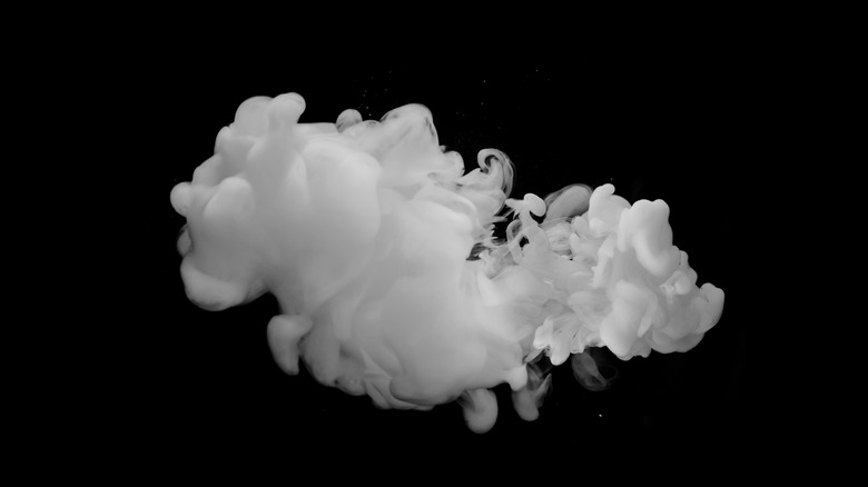 A puff of white smoke against a black background