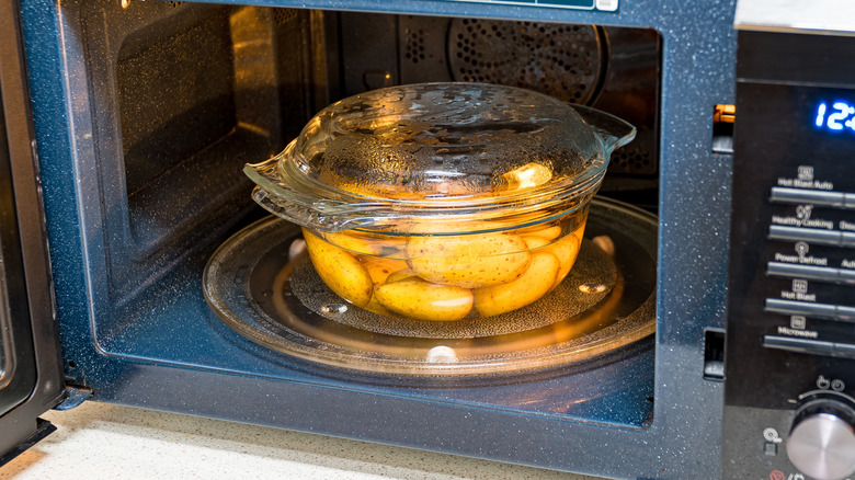 Unpeeled potatoes being heated in a microwave