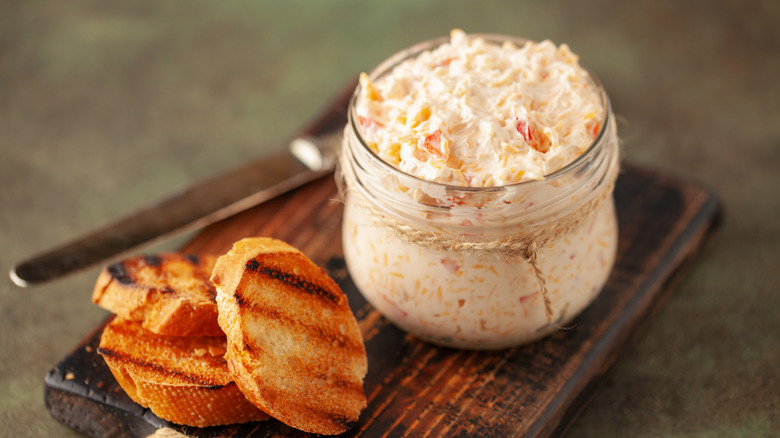Cream cheese dip in a glass jar beside toasted bread