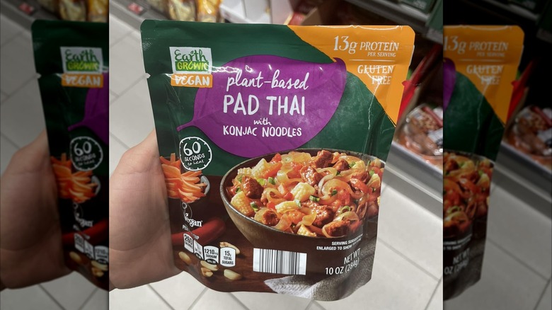 A hand holds a bag of Aldi's vegan pad Thai