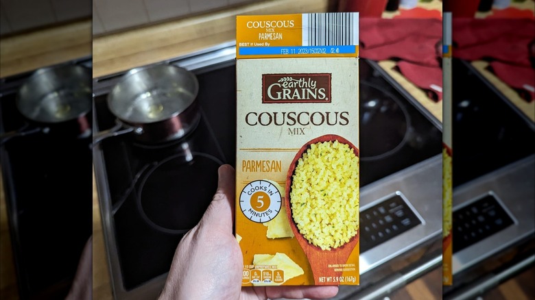 A hand holds a box of Aldi's couscous