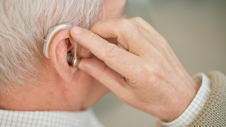 Person using their hearing aid.