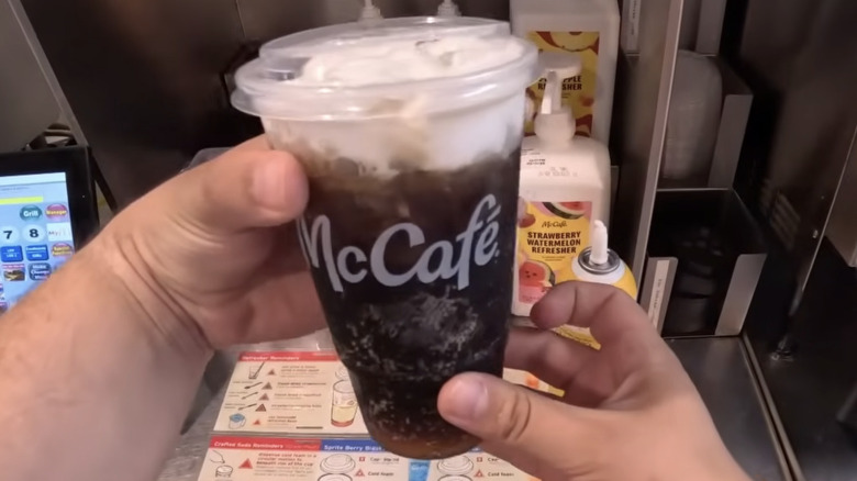 Hands hold the new Dirty Dr Pepper from McCafé