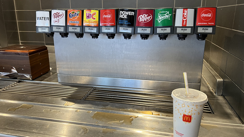 A McDonald's cup sits in front of a soda fountain