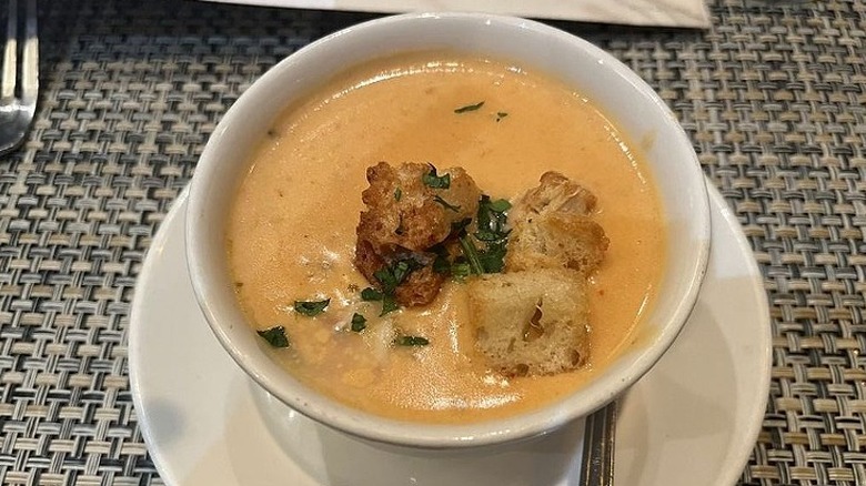 A bowl of McCormick & Schmick's lobster bisque sits on a table in the restaurant