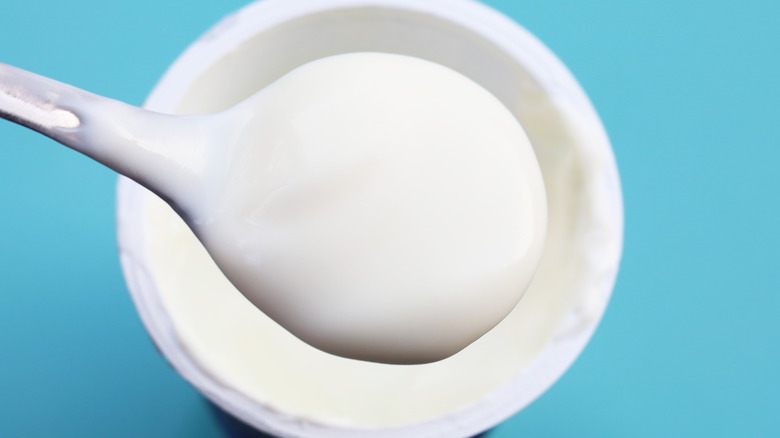 Spooning yogurt from a cup