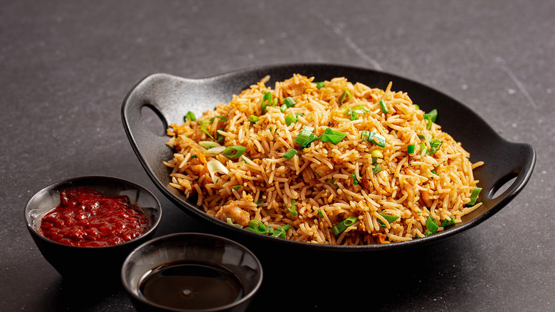 Bowl of fried rice with accompanying sauces