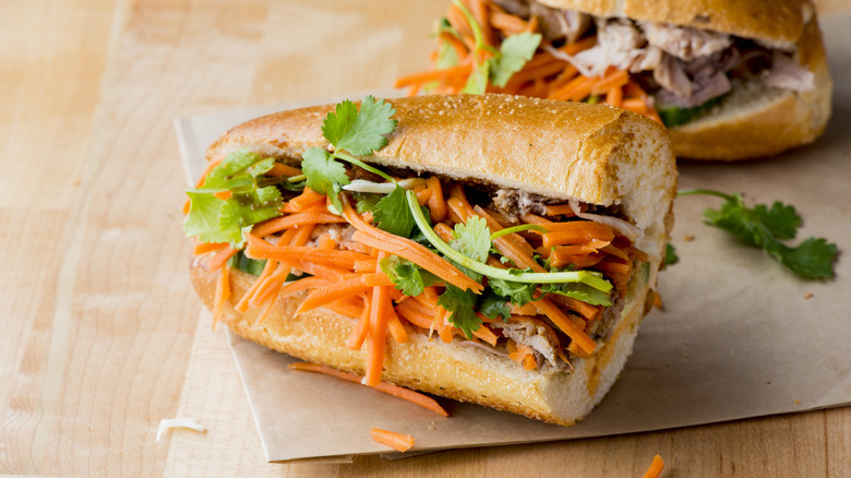Banh mi sandwich filled with pickled vegetables on blonde countertop