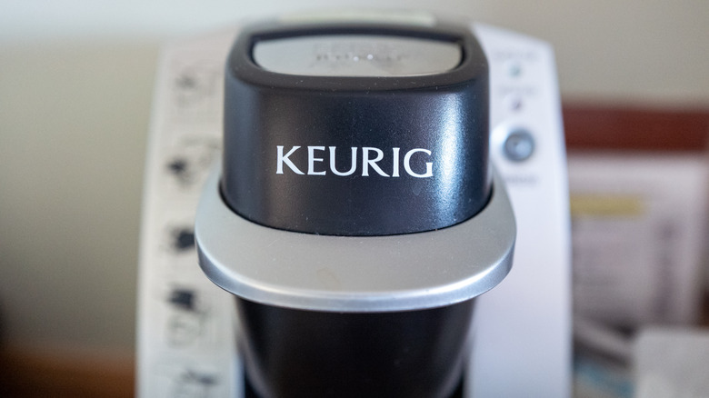 close up of a black and silver Keurig machine with logo