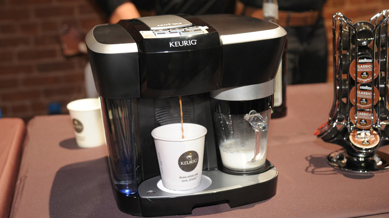 exterior of black Keurig coffee machine brewing coffee and milk