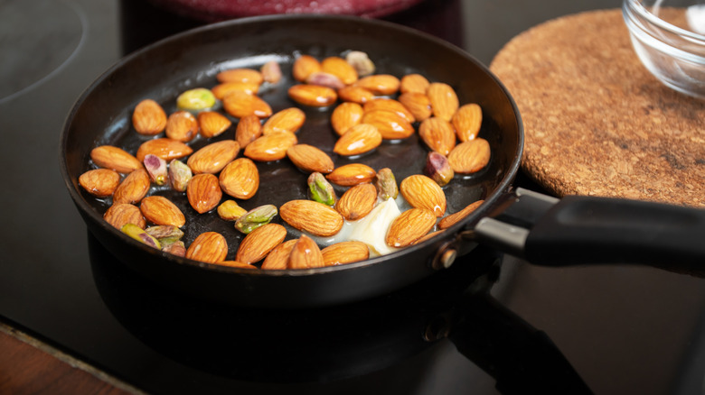 Almonds and pistachios frying in butter