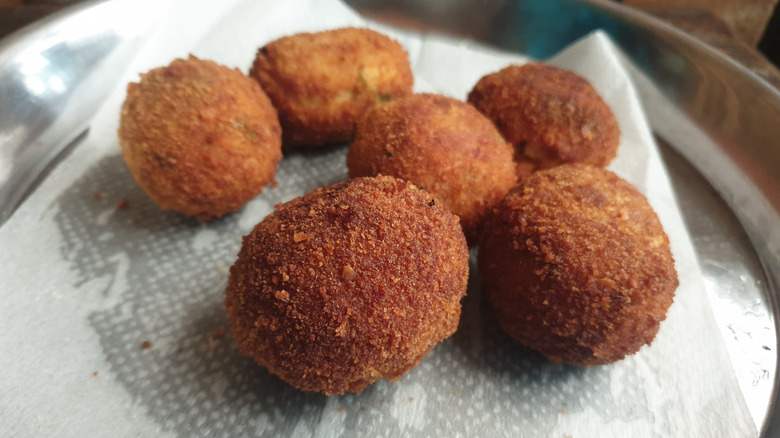 Croquetas on a damp paper towel in a dish