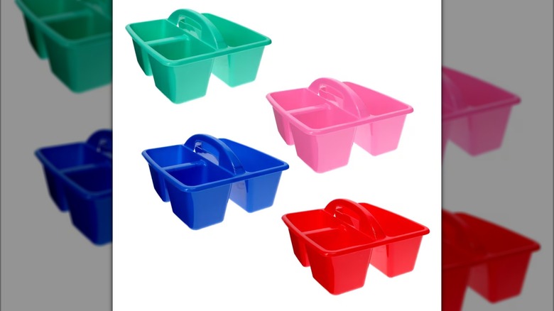 Four plastic storage caddies -- one blue, one green, one pink, and one red -- each with three storage compartments and a handle