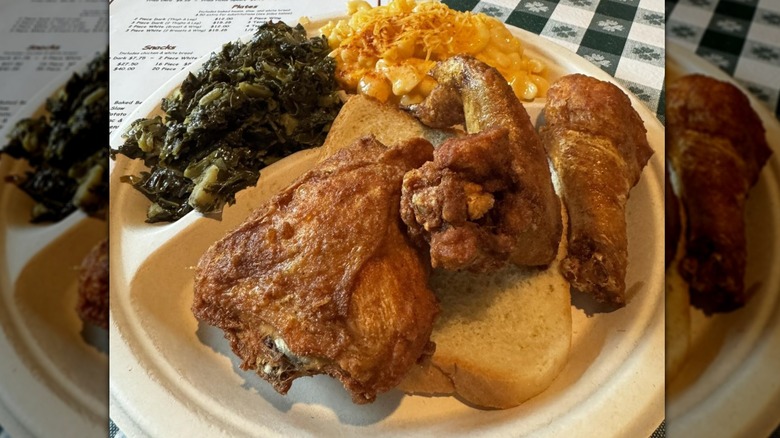 Gus's World Famou Fried Chicken, collard greens, mac n cheese on a light brown plate