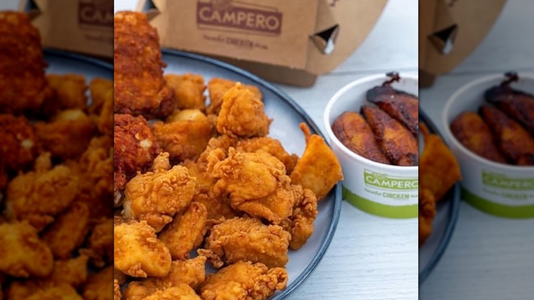 Pollo Campero chicken on a gray plate next to fried plantains in a white container placed on a light gray table