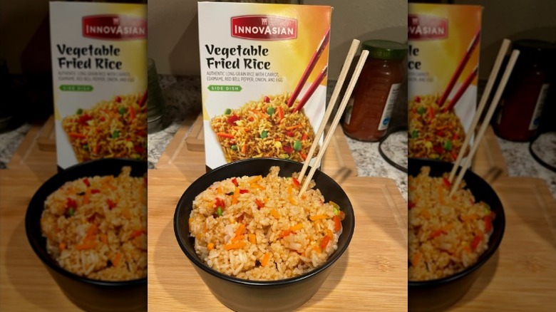 A bowl of Vegetable Fried Rice by InnovAsians on a wooden counter