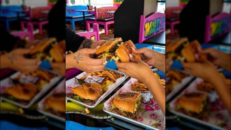 Two people toasting with tortas
