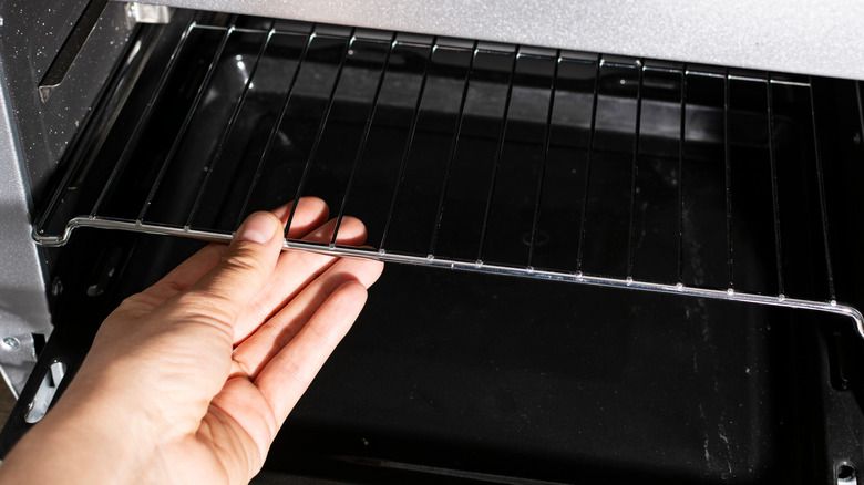 person putting rack in oven