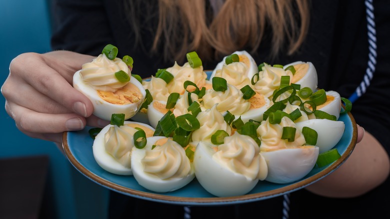 person holding a platter of deviled eggs