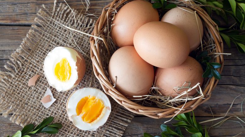 halved hard-boiled egg with whole eggs in a basket