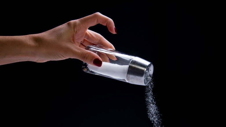Woman pouring salt from a shaker