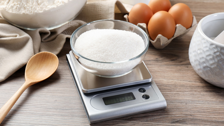 Digital kitchen scale on counter filled with sugar