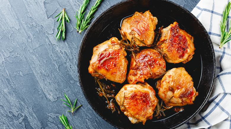Chicken thighs in a cast iron pan with crispy skin