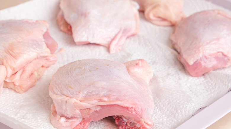 Chicken thighs drying on a paper towel