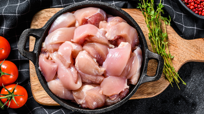 Raw chicken piled up in a frying pan