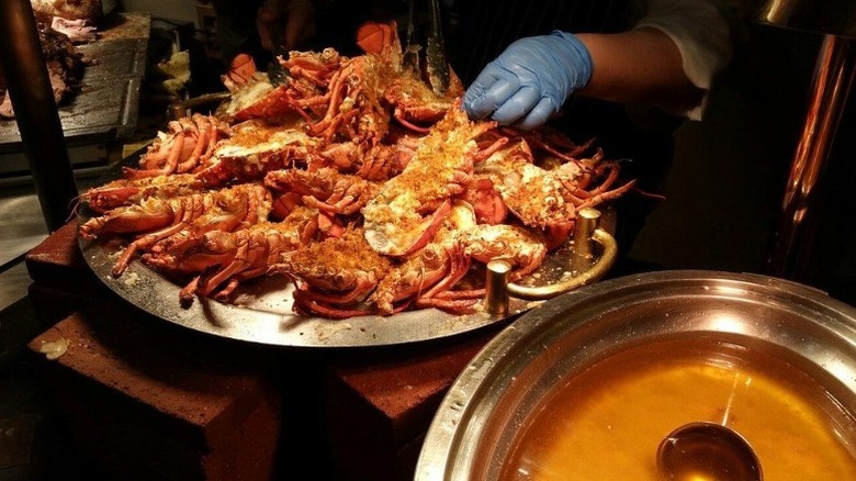 A platter of split lobsters sits next to a bowl of butter at the Cafe Sierra seafood buffet