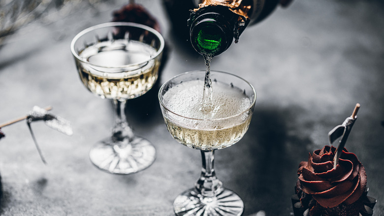 Champagne being poured into coupe glasses