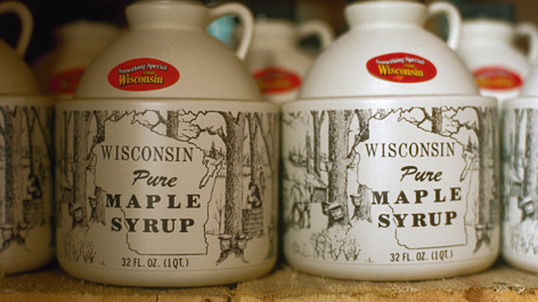 Jugs of maple syrup on wooden shelf