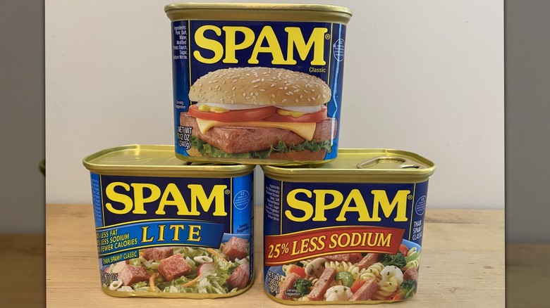 Three cans of Spam stacked in a pyramid shape.