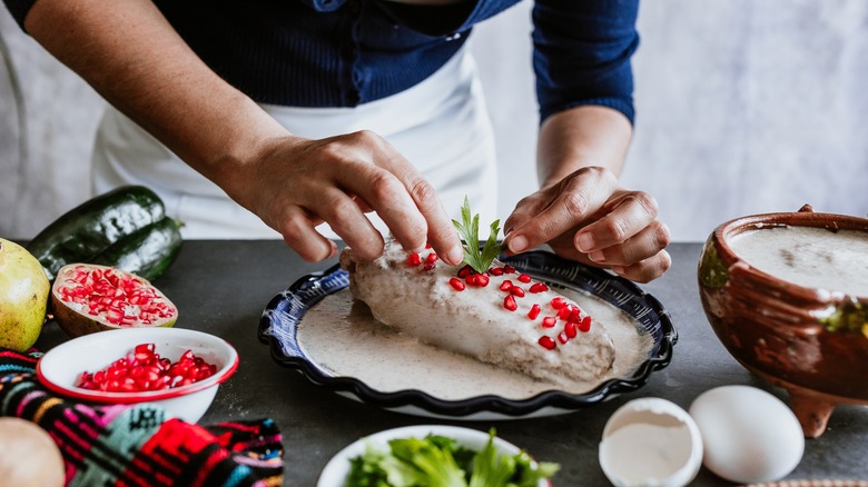 hands preparing stuffed poblano peppers