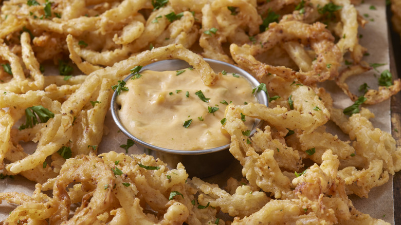 Onion strings with cup of dipping sauce
