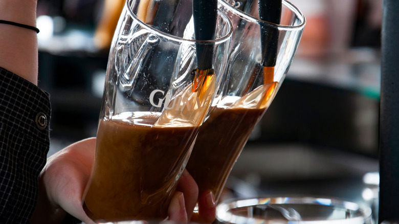 Two pints of Guinness being poured