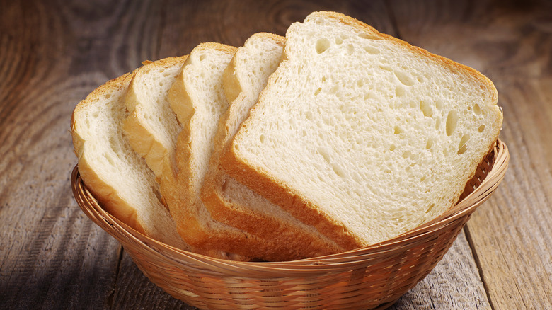 basket of white bread slices on wooden table
