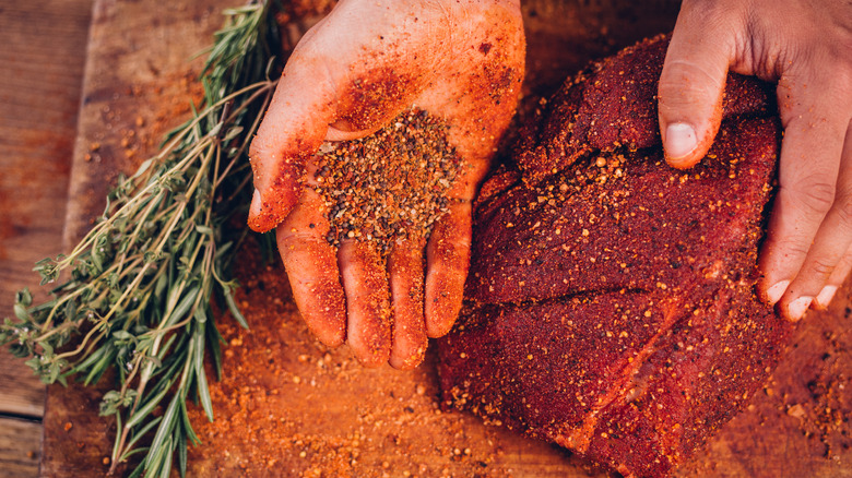 applying dry rub on meat