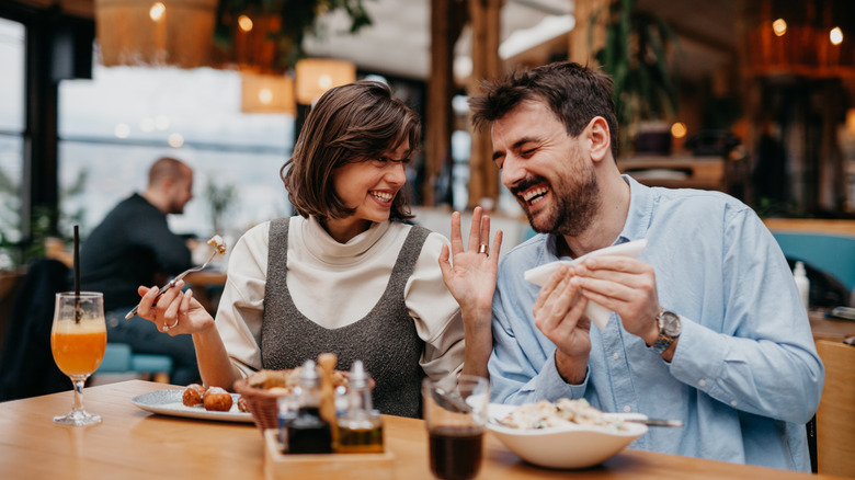 Casually dressed diners laughing at a restaurant