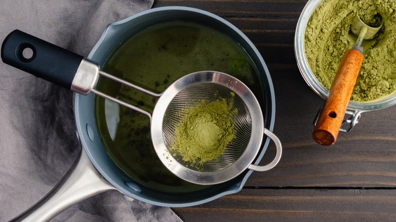Sifting matcha powder into a saucepan