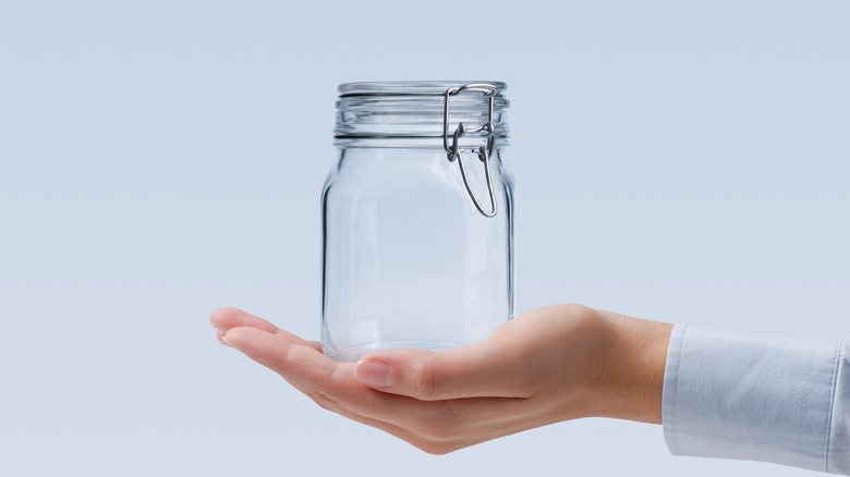Hand holding an empty flip top jar