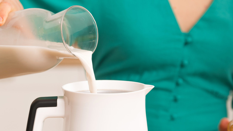 White milk frother jug with black handle
