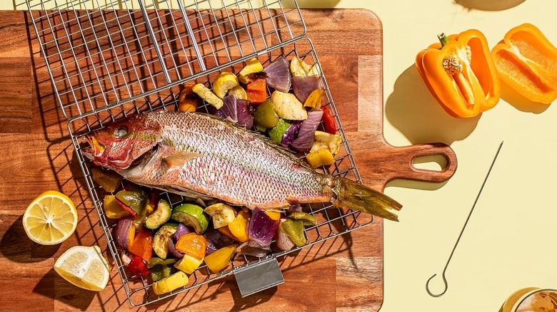 A Shizzo﻿ grill basket topped with veggies and fish.