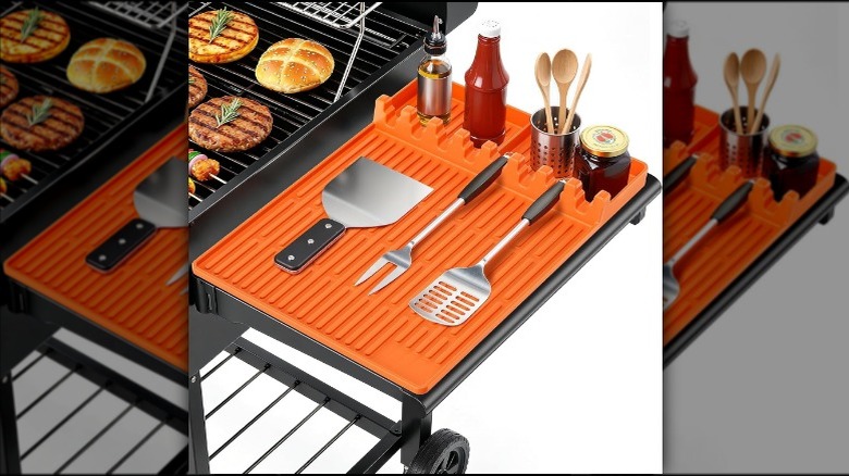 A silicone side shelf pad for cooking sits next to a grill.