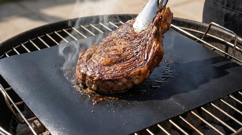 A steak gets lifted off a Renook﻿ grill mat.